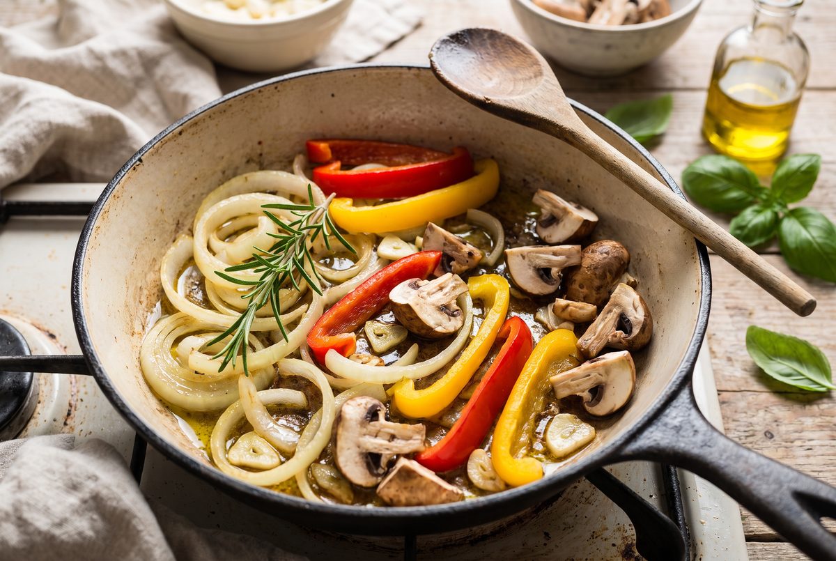 Onion, bell peppers and mushrooms softening in the same skillet