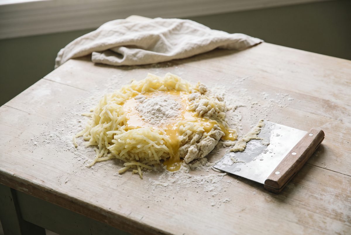 Riced potato, egg and flour just combined into a soft dough with a bench scraper alongside
